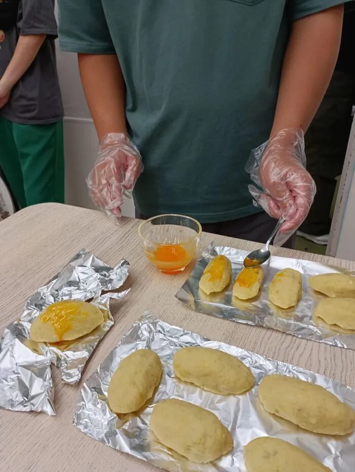 焼く前に卵黄を塗ったスイートポテトが並ぶ天板