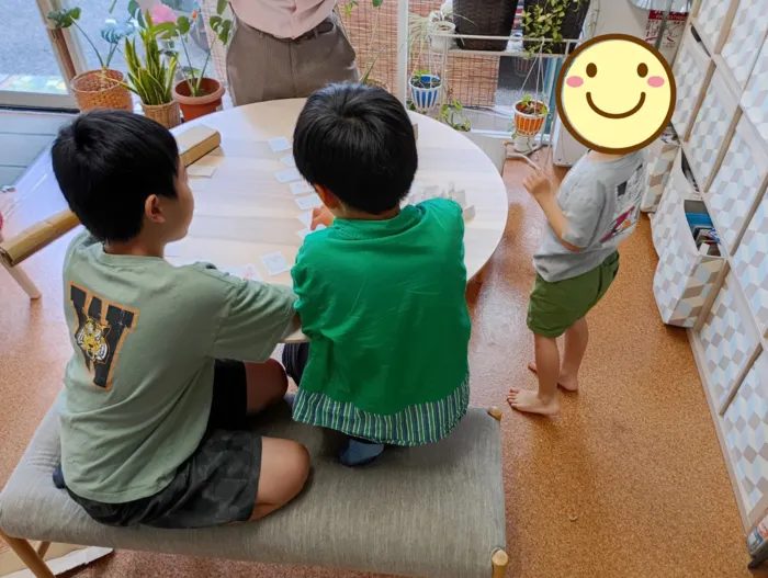 テーブルを囲んで友だちとボードゲームをする子どもたち