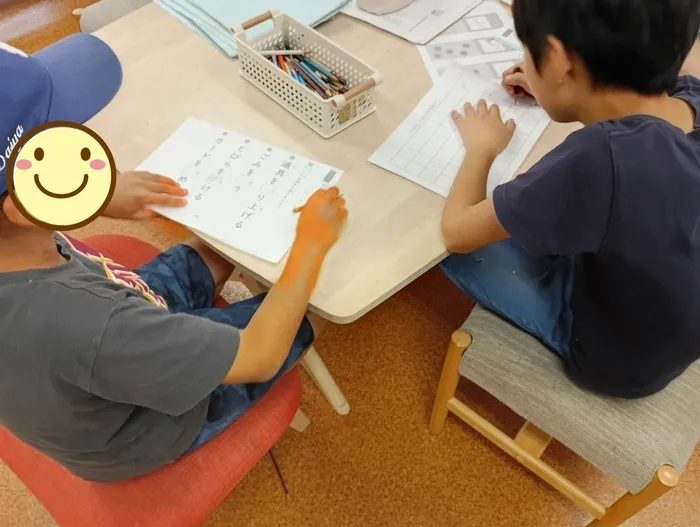 机に向かってプリントの課題に取り組む子どもたち