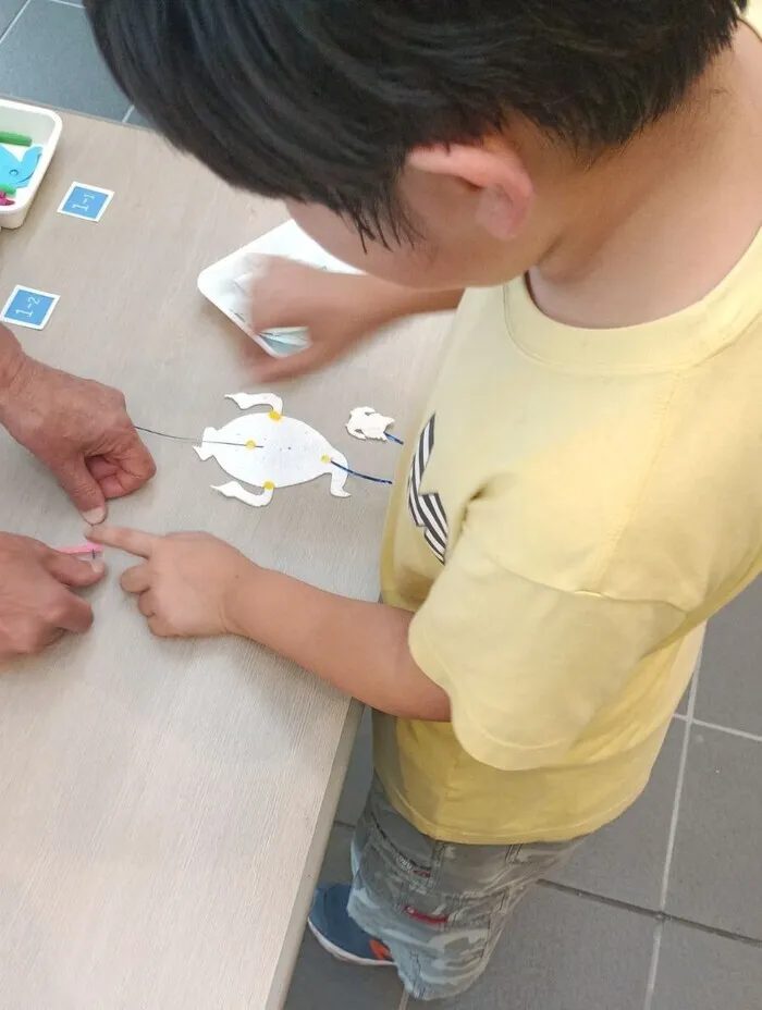 工作体験でミニ凧を仕上げる子どもの手元